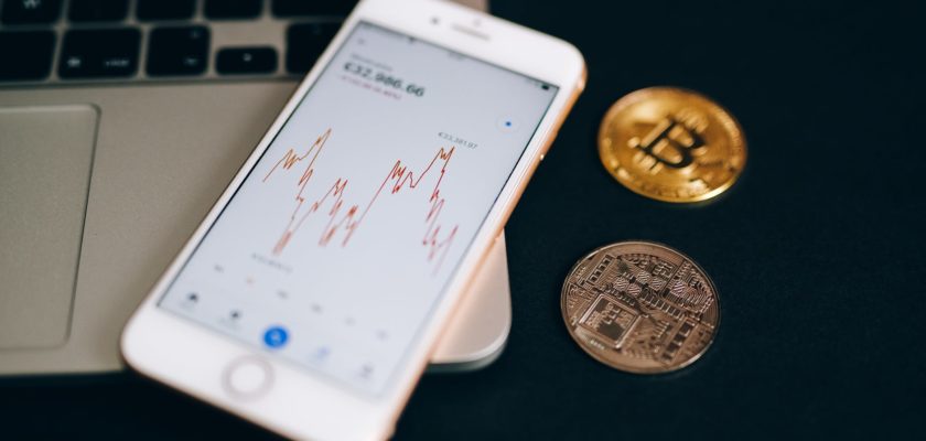 close up shot of a smartphone and bitcoins