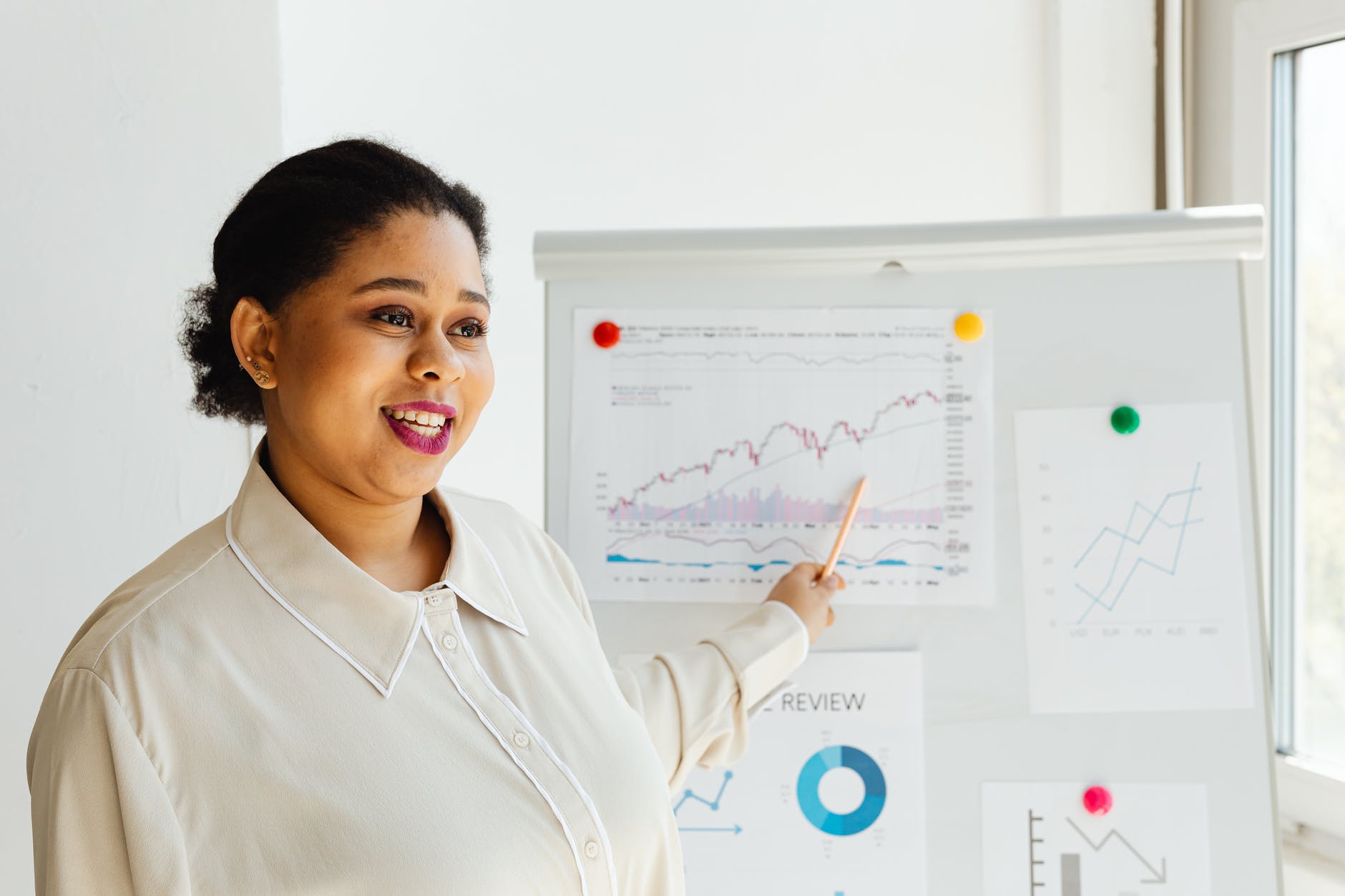 a woman pointing a graph posted on a white board