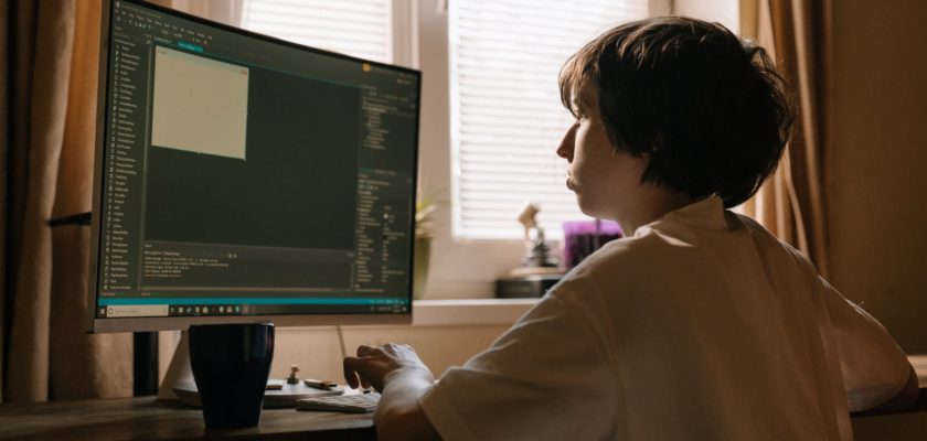 boy in white long sleeve shirt playing computer game