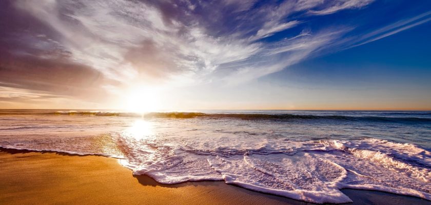 seashore under white and blue sky during sunset