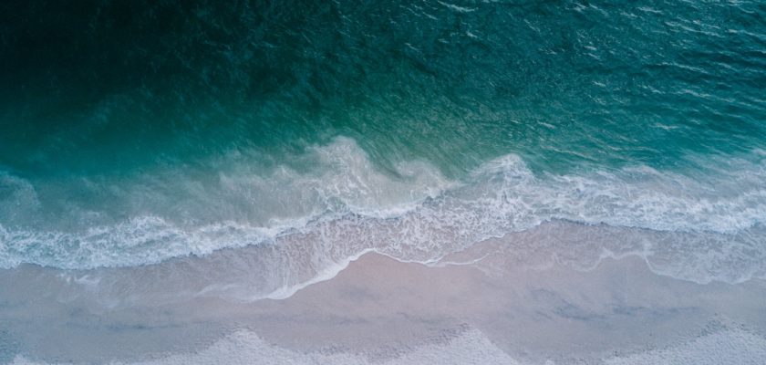 body of water beside beach sand